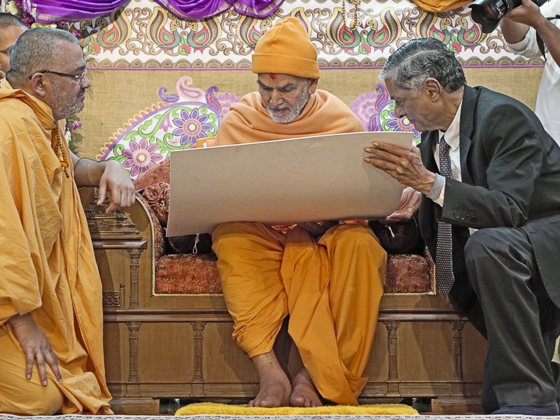 Head, Dr. Bhadresh Swamiji, and Director, Dr. JM Dave, present BAPS Swaminarayan Research Institute’s new website to Param Pujya Mahant Swamiji Maharaj